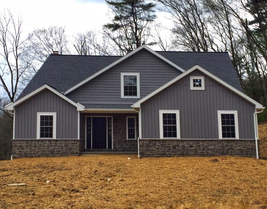 The front of a custom-built Berks County home with dark charcoal grey horiztonal and board & batten siding and white trim