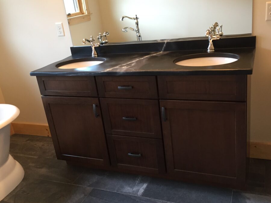 The Master Bathroom's soapstone countertop vanity with Delta faucets, Kemper cabinetry and tiled flooring. 