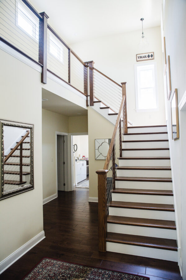 Stairs are Open Mitre with Oak Stained Treads and Painted Risers with cable wire stair railings with stained, mission style box newel and craftsman railing. 