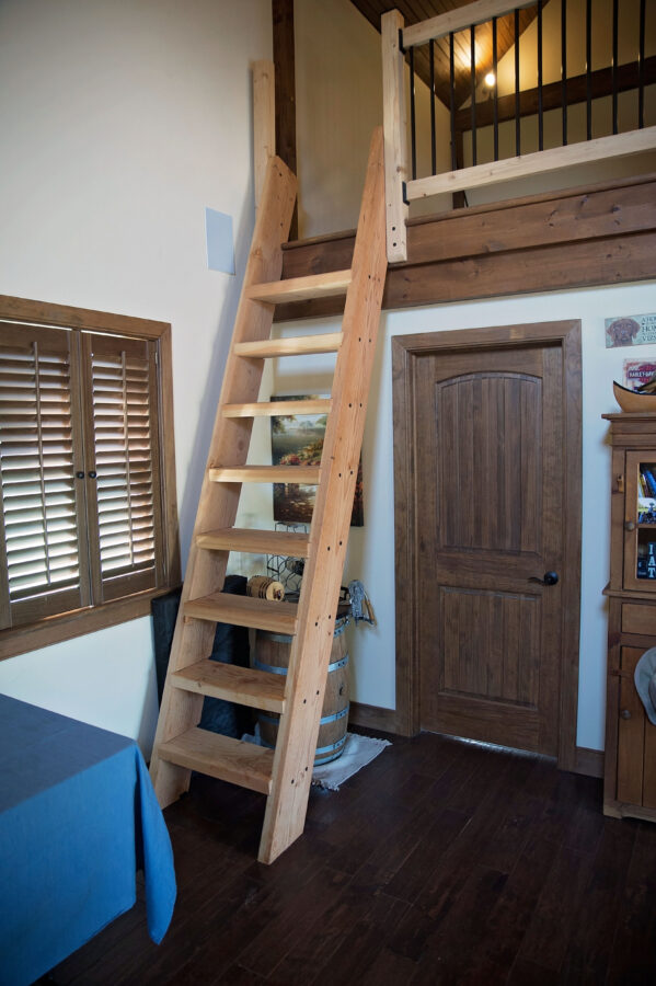 Wooden ladder steps leading to the loft from the main living space
