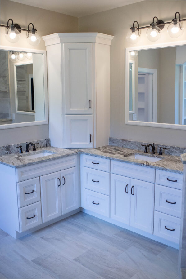 A large master bathroom with white cabinets and double sinks
