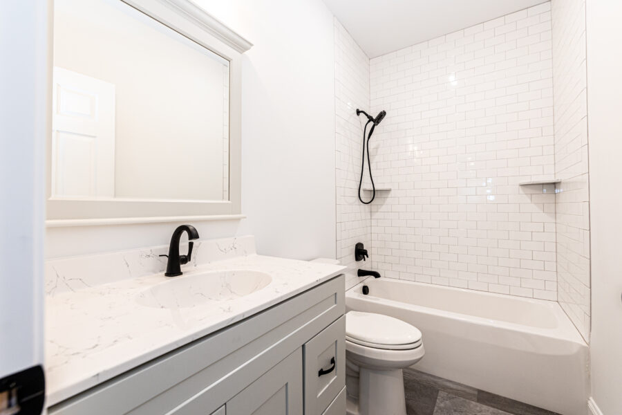 An all white bathroom with oil-rubbed bronze hardware