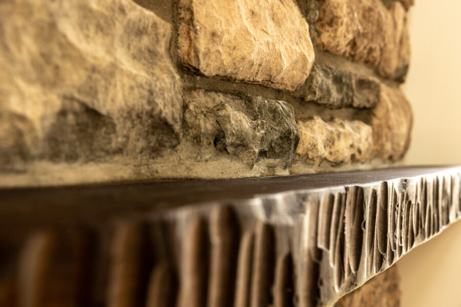 A close-up of the stone and mantle on the fireplace