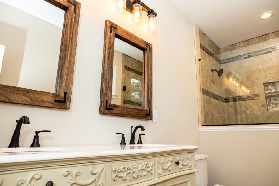 A rustic mirror above and ornate bathroom vanity