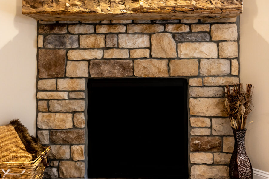 A close-up of a stone fireplace in the corner of the living room