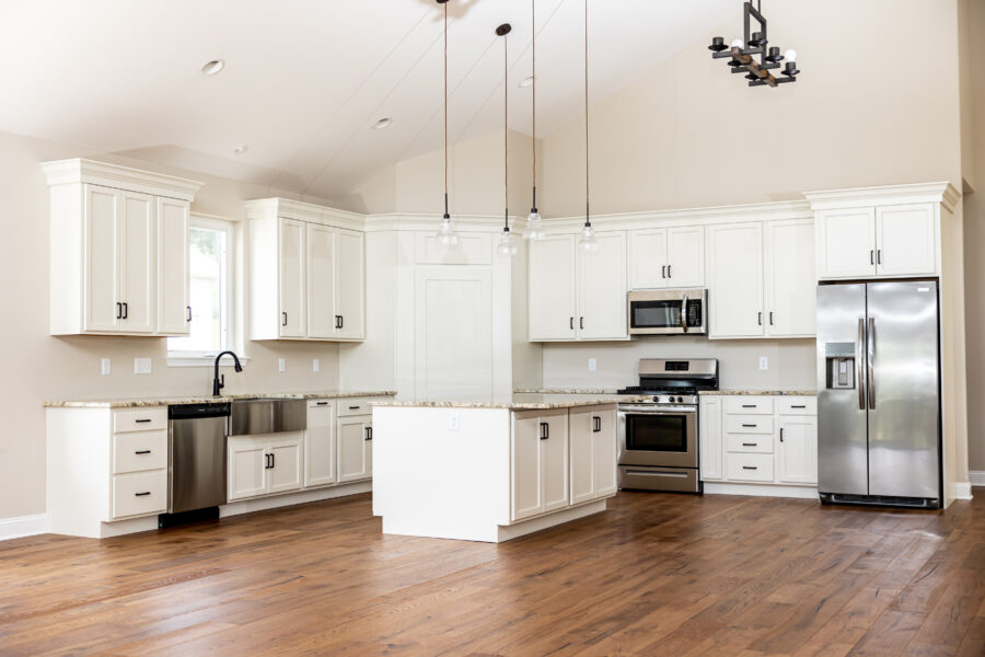 The modern kitchen with white cabinets, stainless steel appliances and hardwood floors