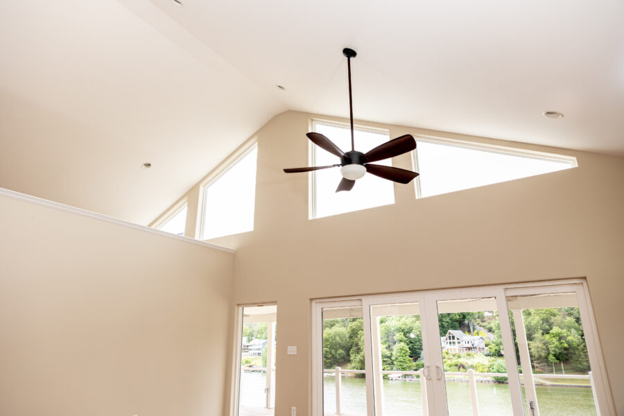 High ceilings with a ceiling fan and high windows