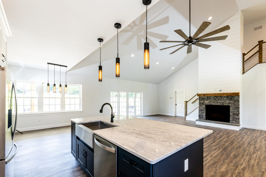 The modern kitchen with hanging lights and an island with a sink