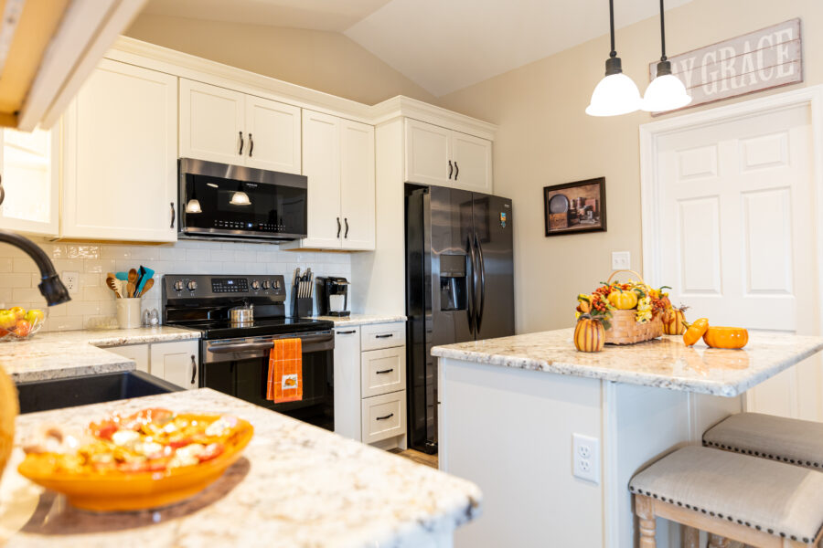 A custom-built kitchen with white cabinets and new appliances