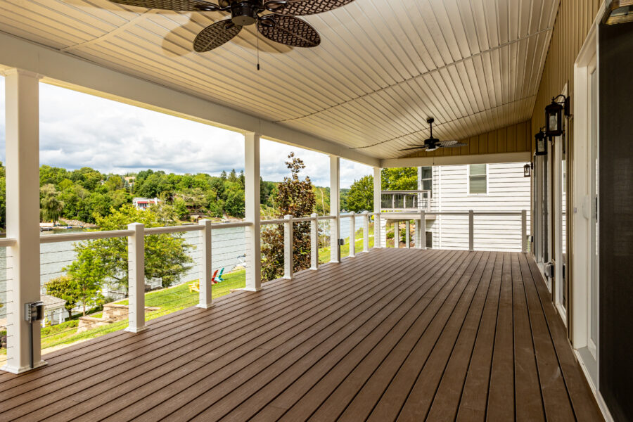 A covered deck porch with a ceiling fan