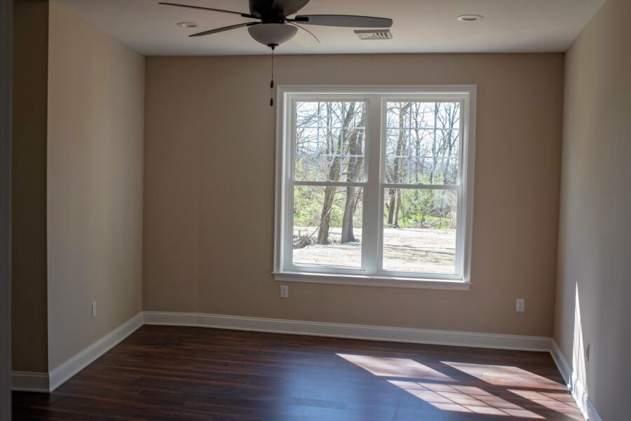Bedroom with hardwood floors and natural lighting through windows