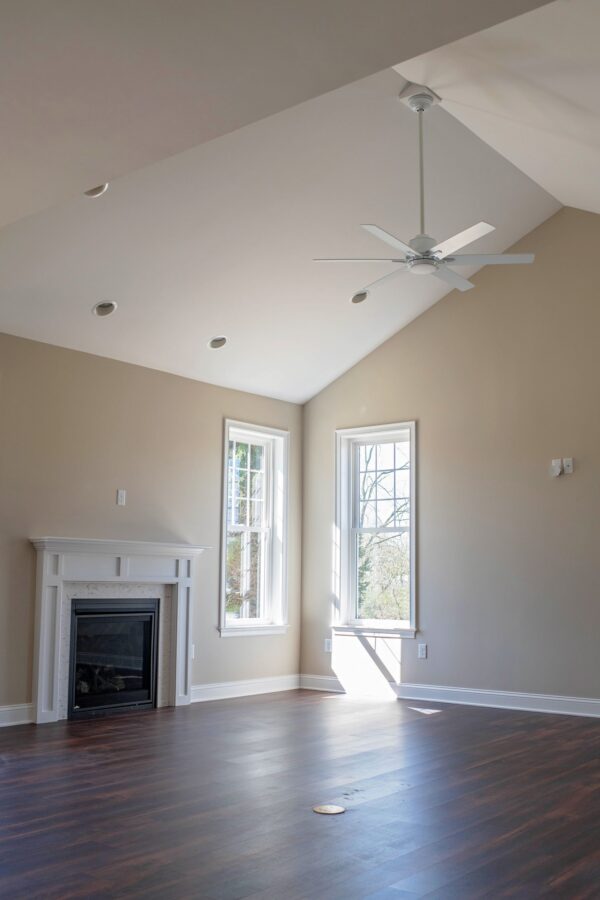 The great room with natural lighting, hardwood floors & fireplace