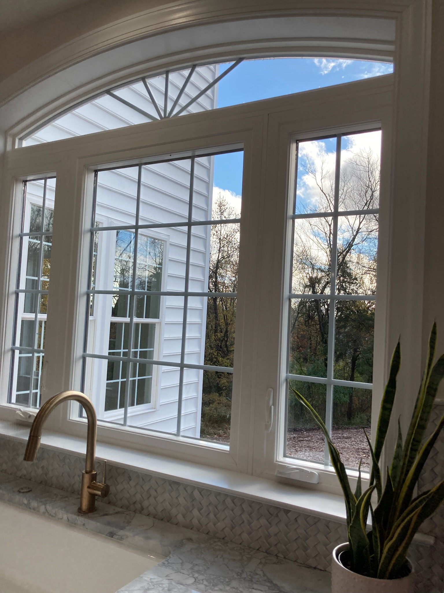 A large white window above the kitchen sink